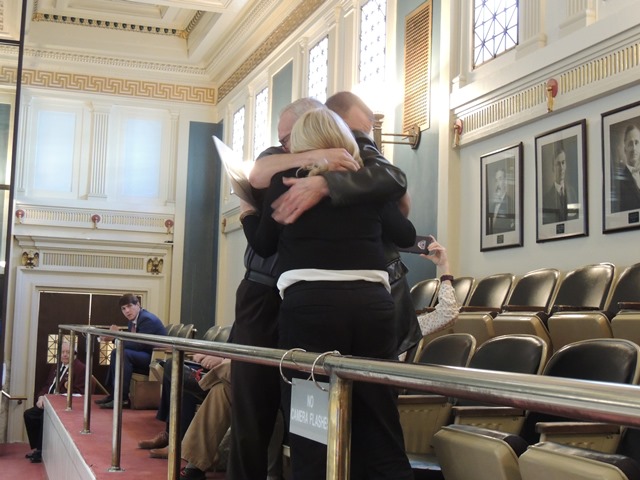 Francine Frost’s husband, Malcolm Frost, daughter, Vicki Frost Curl and grandson, Cory Curl, hug after the Francine’s Law was approved by the full Senate.