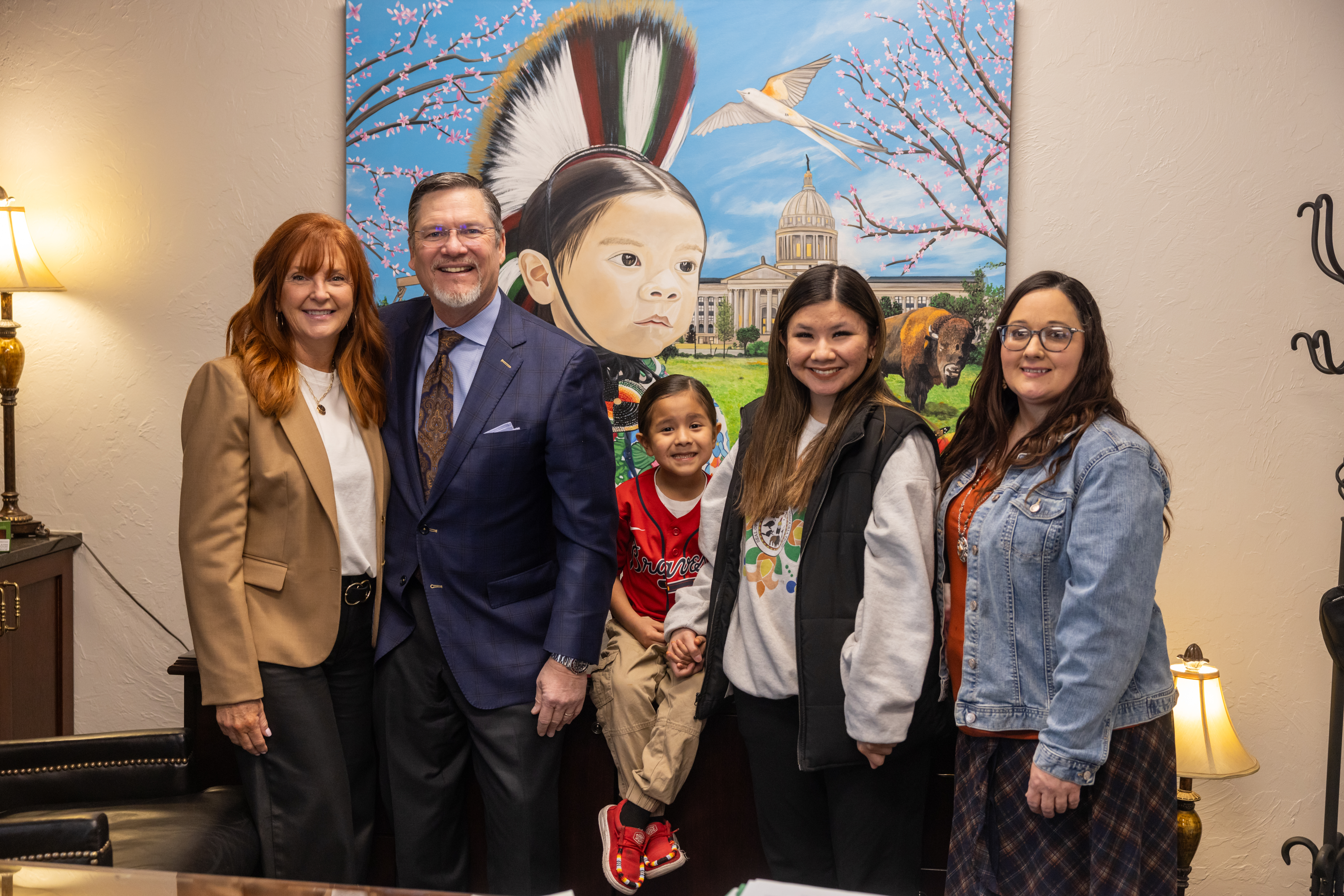 Sen. Chuck Hall, R-Perry and his wife, Amy, pose for a photograph in front of a newly completed painting by Perry artist Holly McHughes. Pictured from left to right: Amy Hall, Sen. Chuck Hall, Kilane George Grant, Nizhoni Jo Childs and artist Holly McHughes.