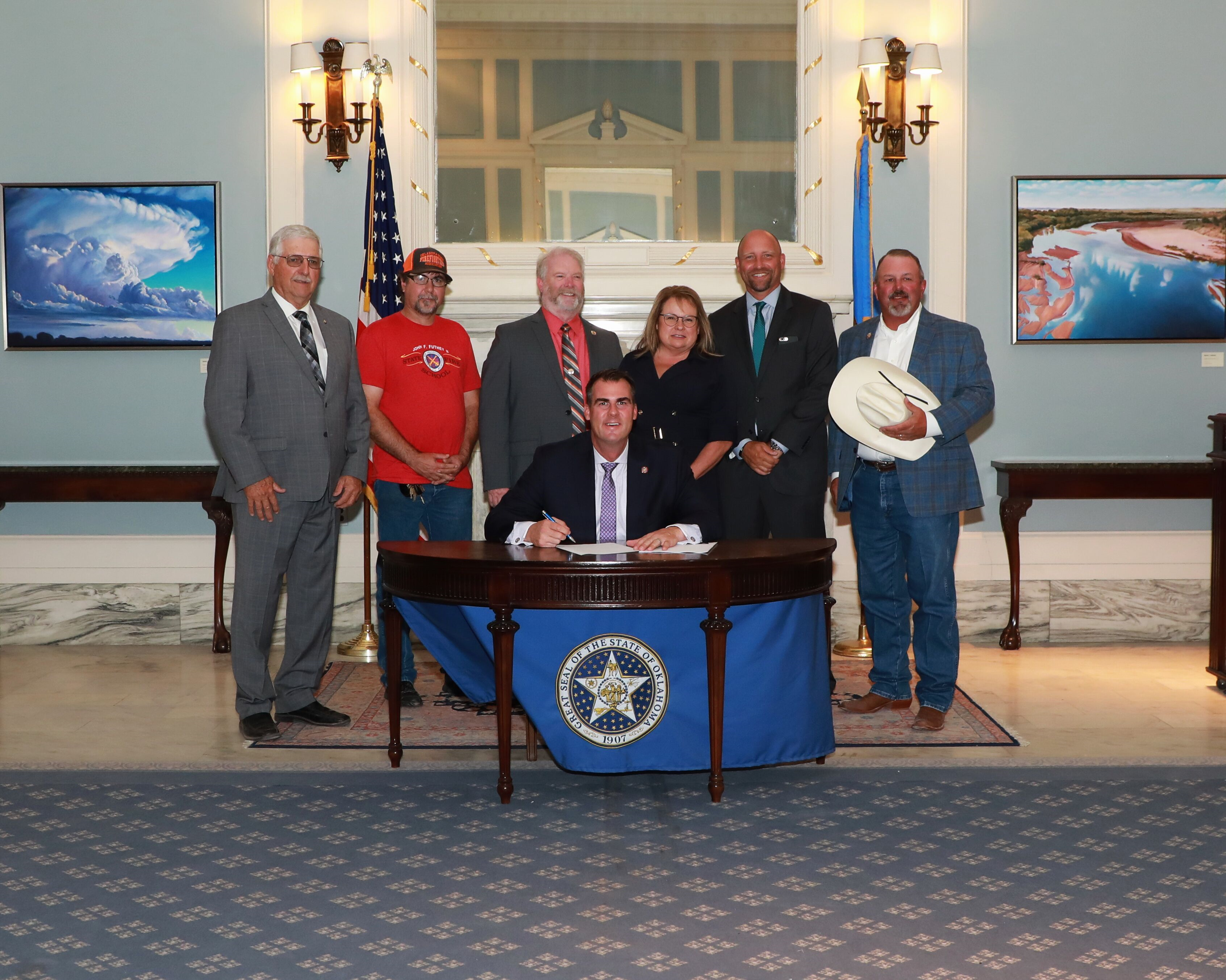A ceremonial bill signing was recently held at the Capitol for SB 164, assisting rural fire districts.  Pictured from left to right are Sen. Roland Pederson, Tim Bartram, Special Projects Coordinator for the Oklahoma State Firefighters Association (OSFA), Steve Lumry, Executive Director, Sheri Nickel, Administrative Director, Rep. Gary Mize, Don Armes, lobbyist, and Gov. Kevin Stitt, seated.
