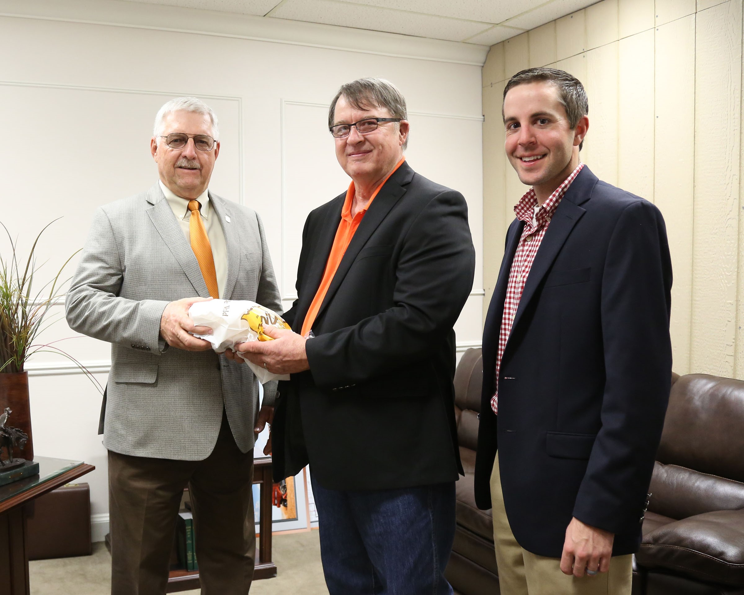 Senator Roland Peterson, R-Burlington, (left) welcomes delegates of the Oklahoma  Wheat Growers Association, RJ Parrish of Hunter (center) and Travis Schnaithman of Garber in  his office last week.  Parrish and Schnaithman helped deliver Oklahoma-made bread to  legislators for the annual Wheat Day at the Capitol.