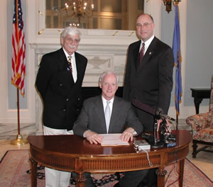 Gov. Frank Keating, with Sen. Ben Robinson (left) and Rep. Ray Vaughn (right) watching, signs SB 1553